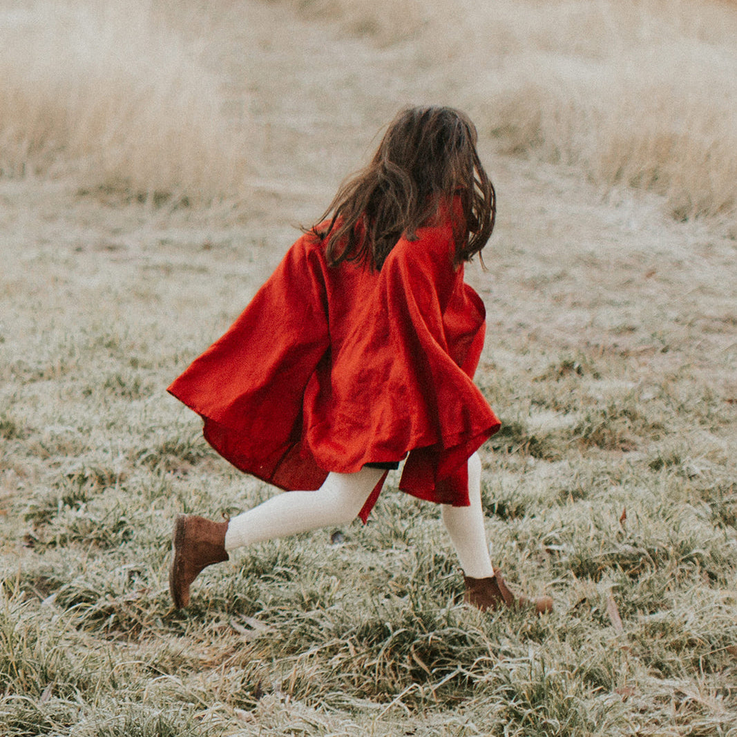 Child running in berry linen collar cape