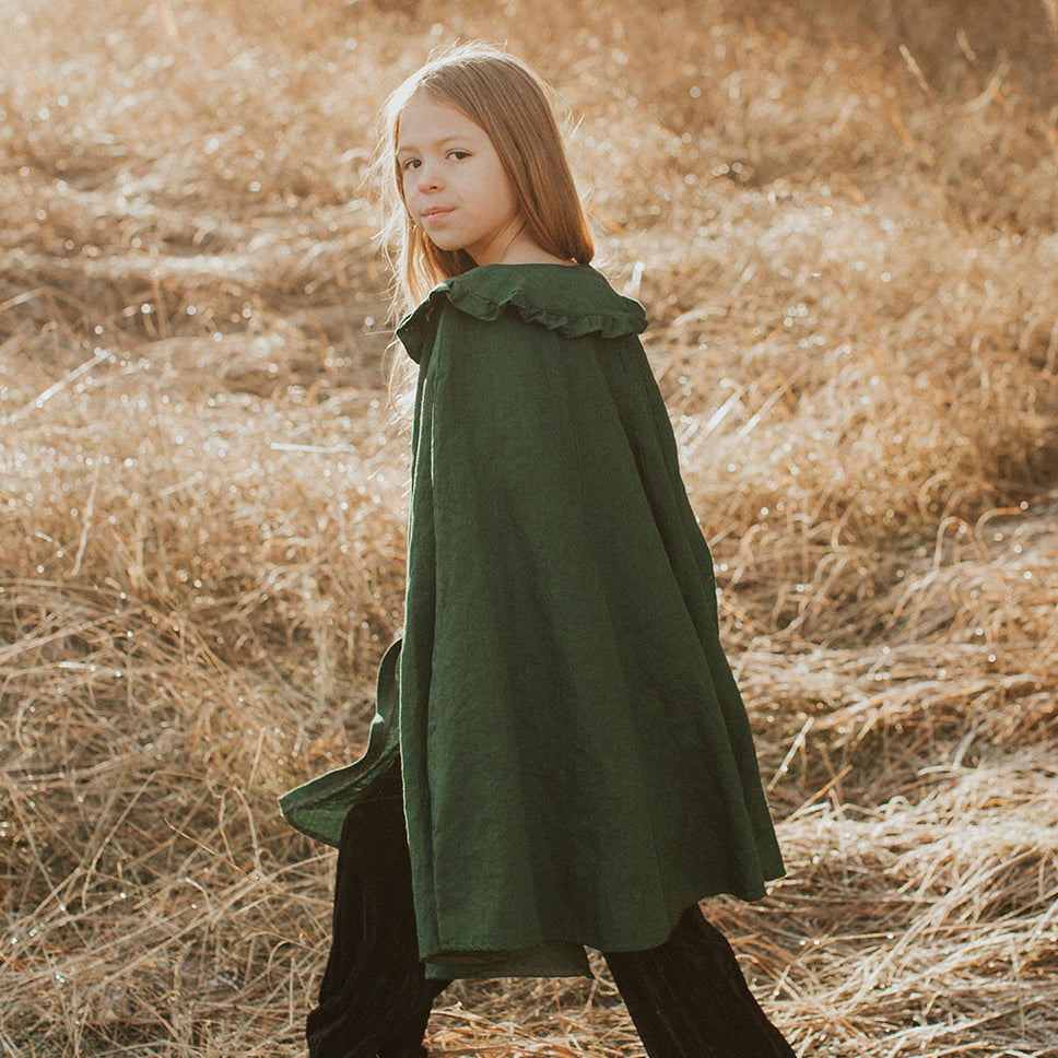 Child wearing linen collar cape in pine green