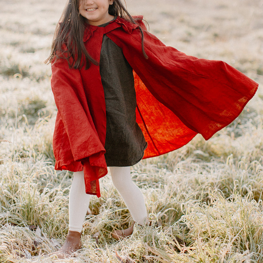 Child twirling in berry linen collar cape